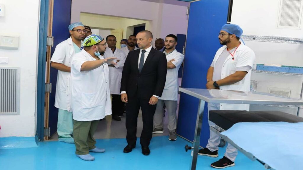 Le ministre de la Santé Amine. Tehraoui en discussion avec une équipe médicale en blouse blanche dans un établissement hospitalier.