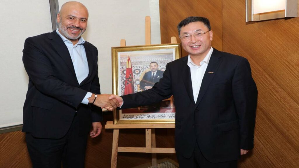 une poignée de main entre le Directeur Général de Marsa Maroc, Tarik El Aroussi, et le Président Directeur Général de ZPMC, You Ruikai, devant un tableau.