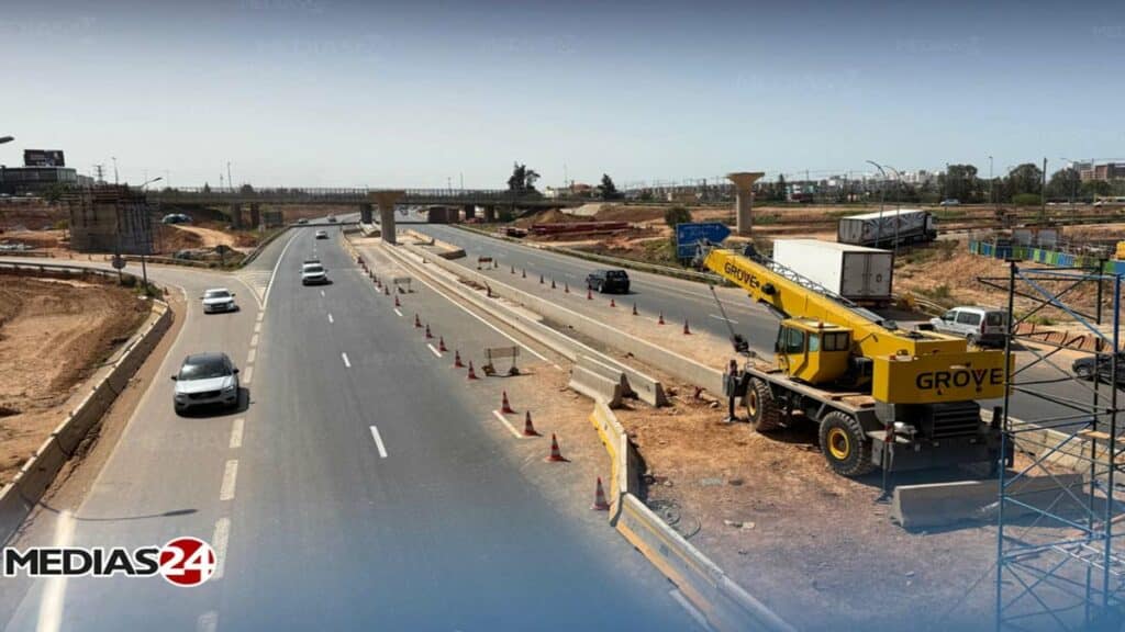 Vue de l’autoroute de contournement de Casablanca au niveau de Sidi Maarouf avec circulation et engins de chantier.